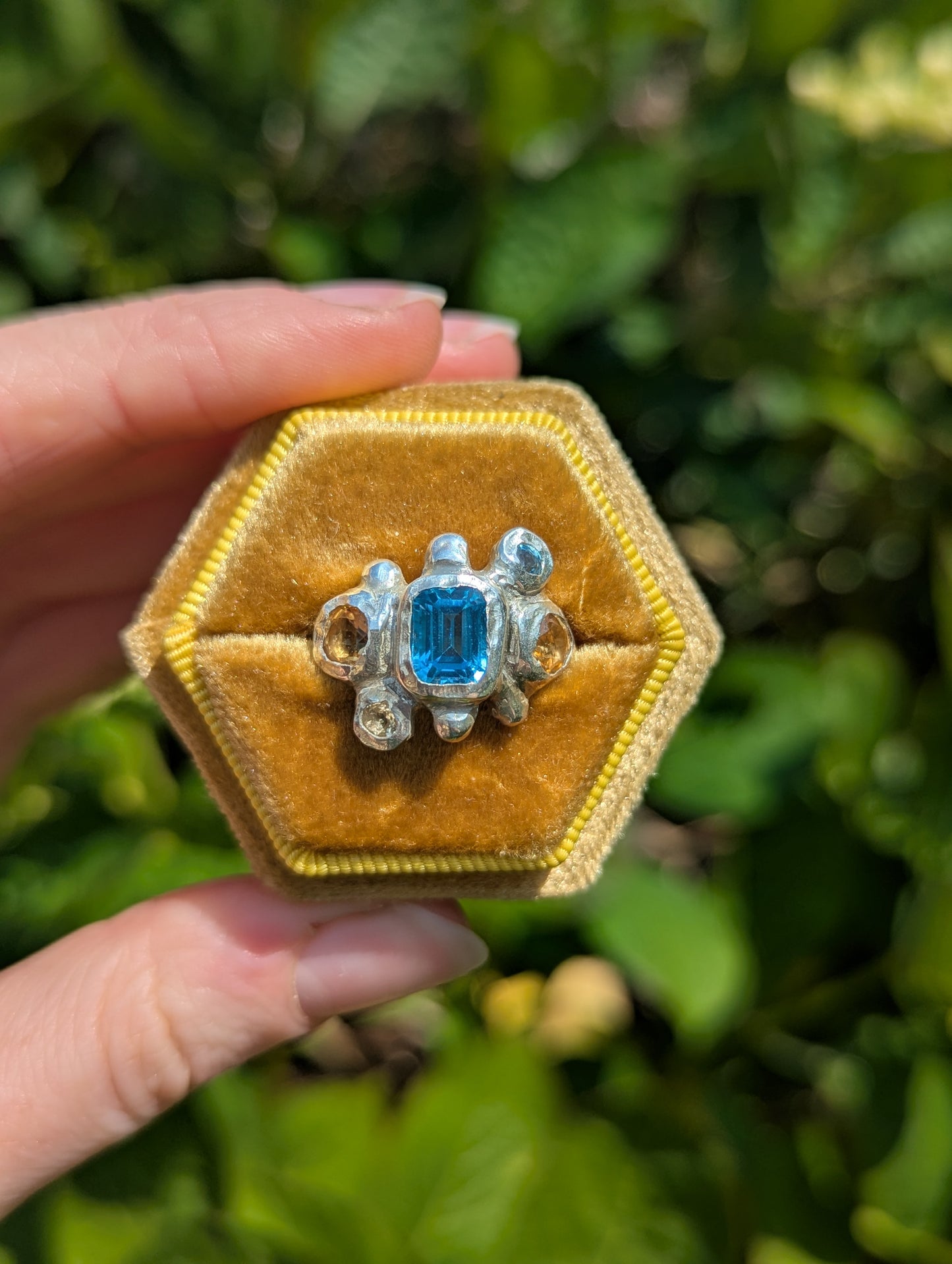 Handmade bohemian silver ring with blue and yellow gemstones in yellow box