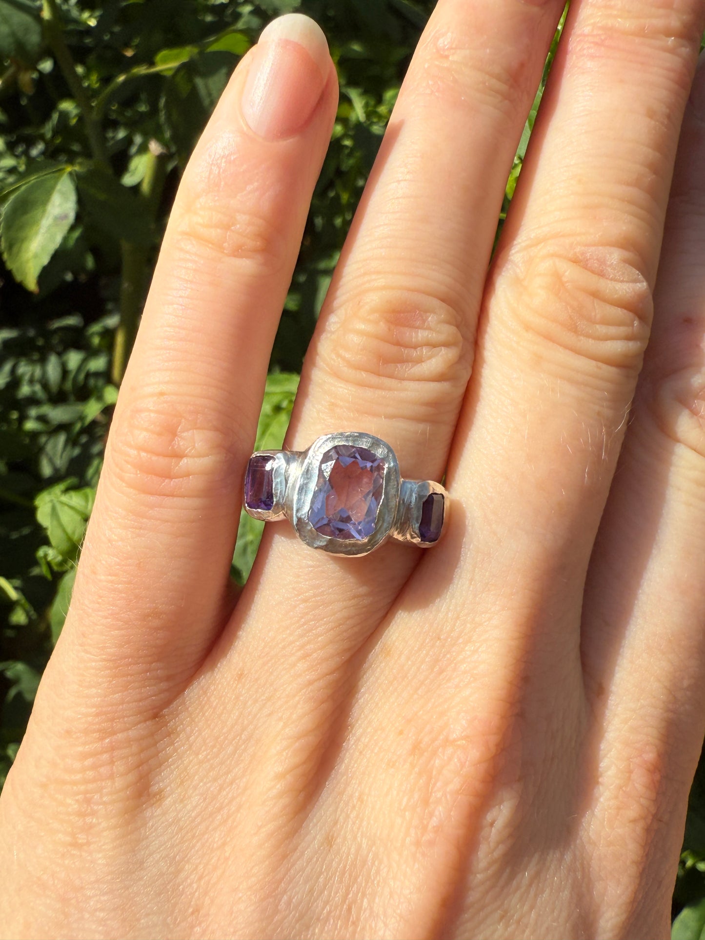 Cushion cut amethyst bohemian handmade silver ring in front of leaves