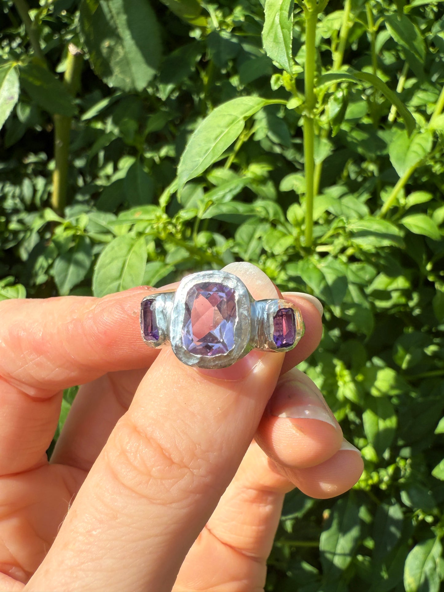 Cushion cut amethyst bohemian handmade silver ring in front of leaves 2