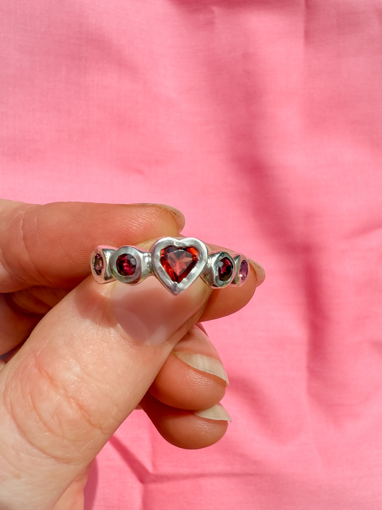 Silver ring with red heart shaped gemstones