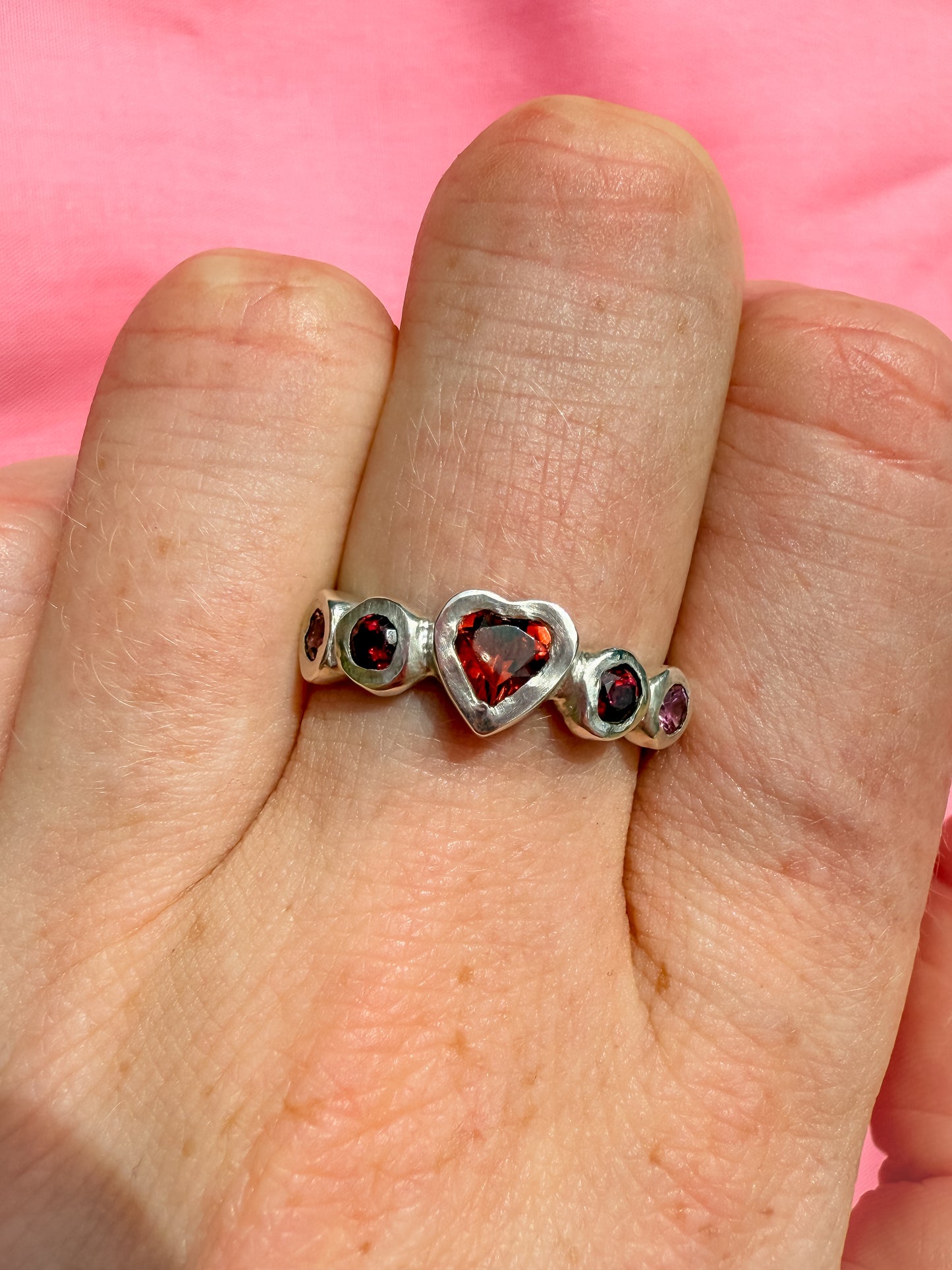 Silver heart shaped ring with red heart gemstones and pink and red gemstones