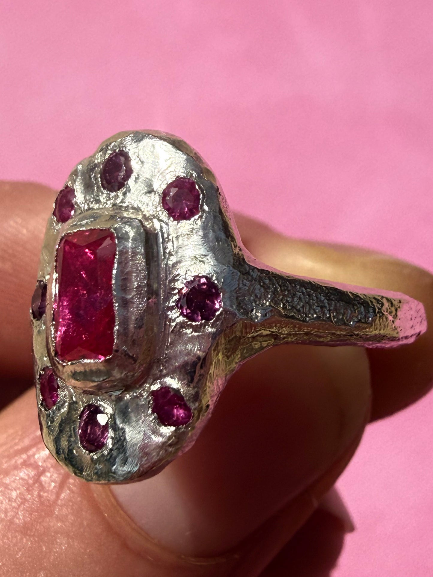 Lab ruby, rhodolite and ruby handmade silver oval ring up close sand cast texture on ring shank 4