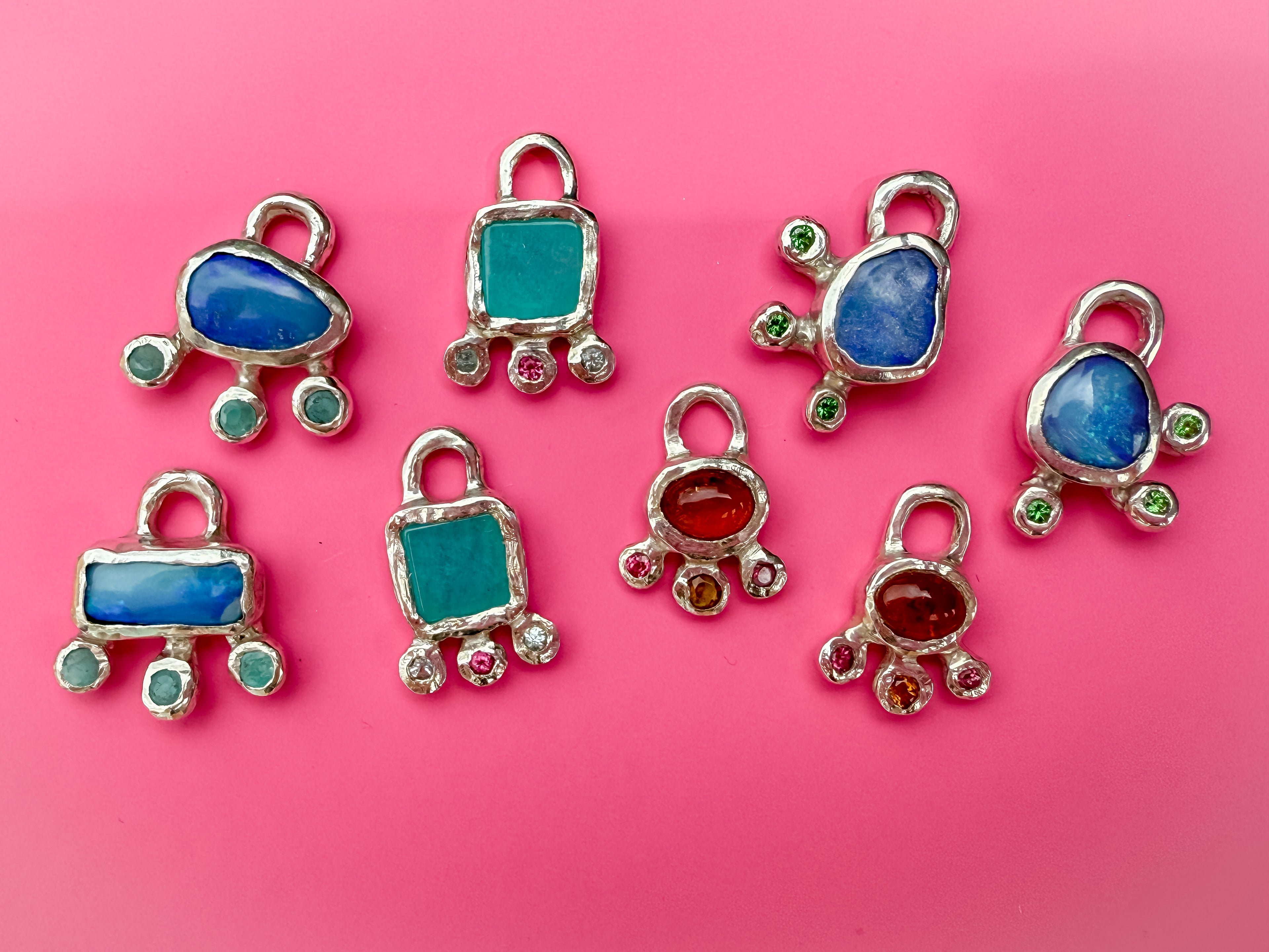 Colourful earring silver charms against pink background