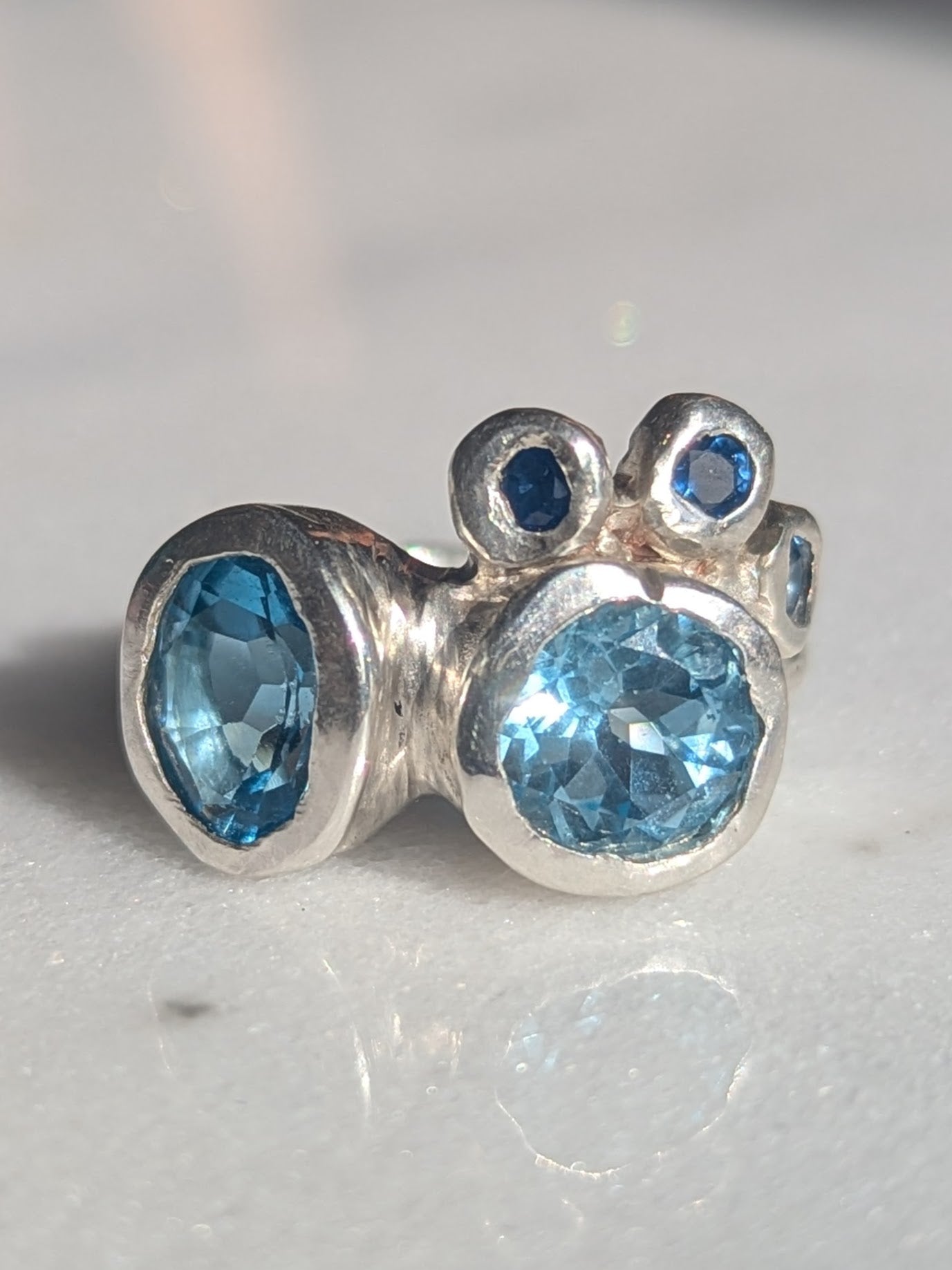 Silver ring with blue gemstones on a white background