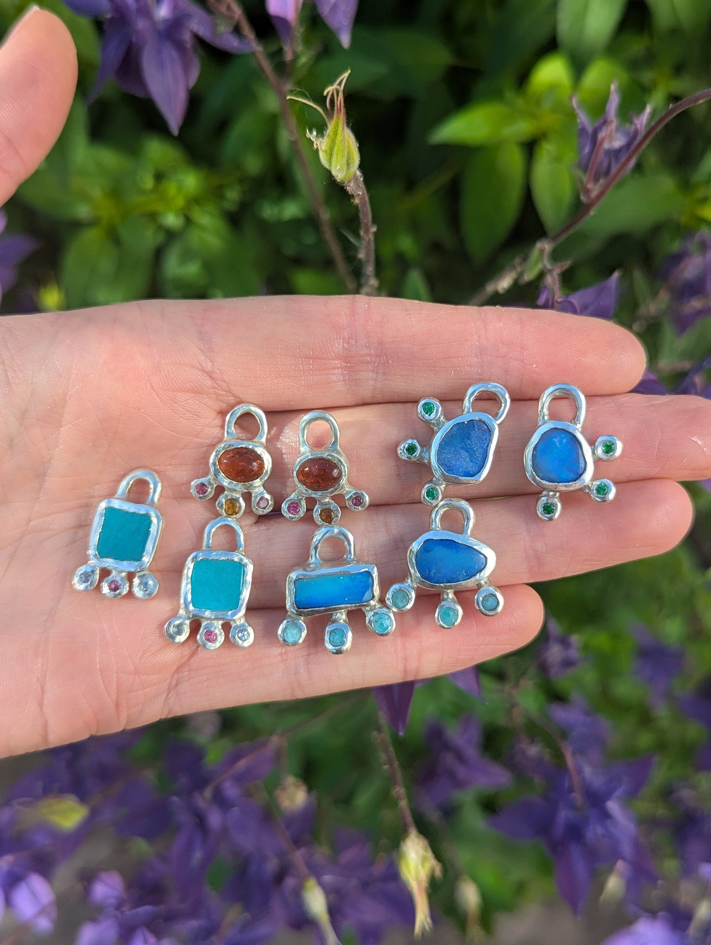 Hand holding silver earring charms