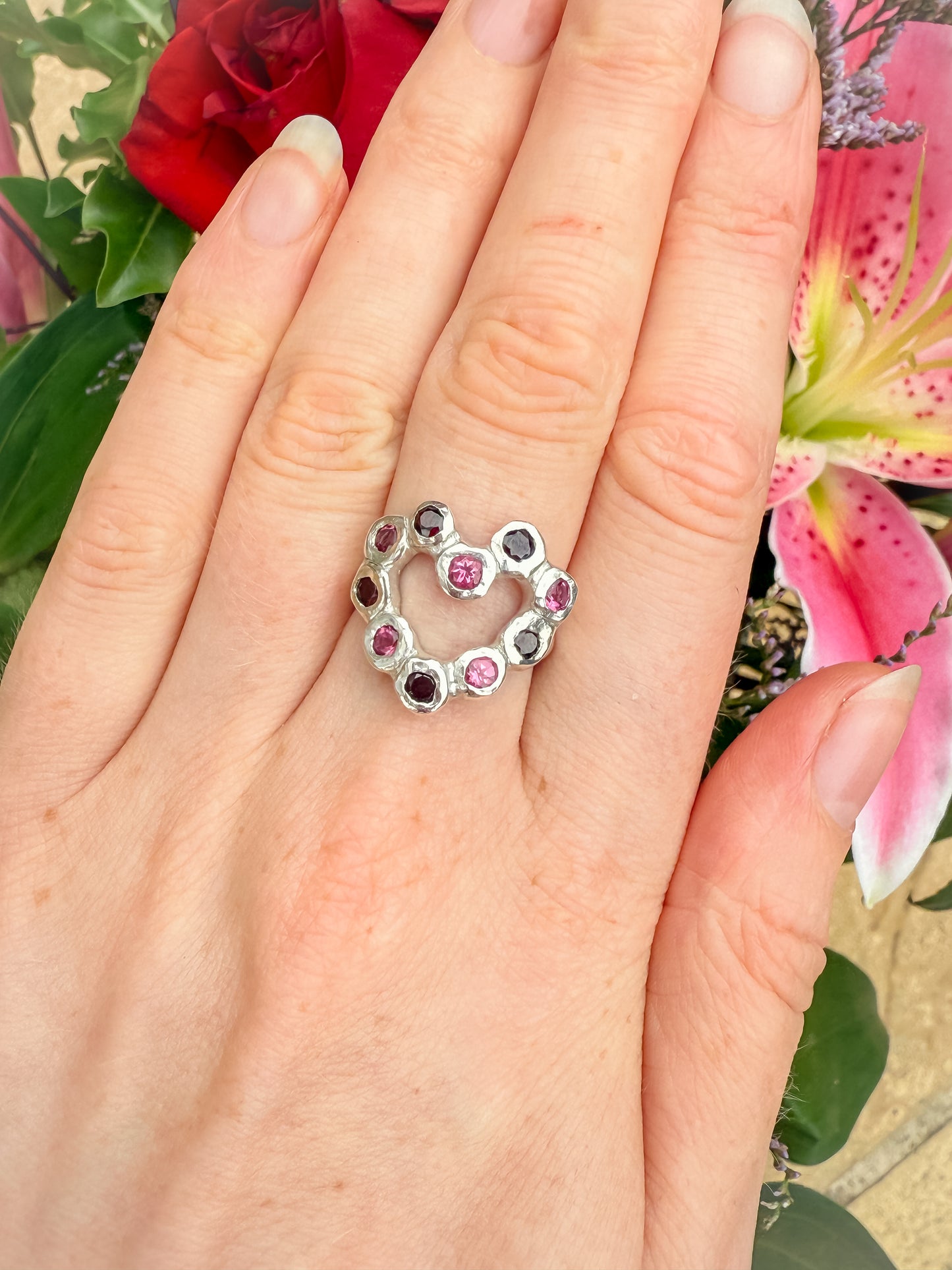 Silver heart shaped ring with pink and red gemstones