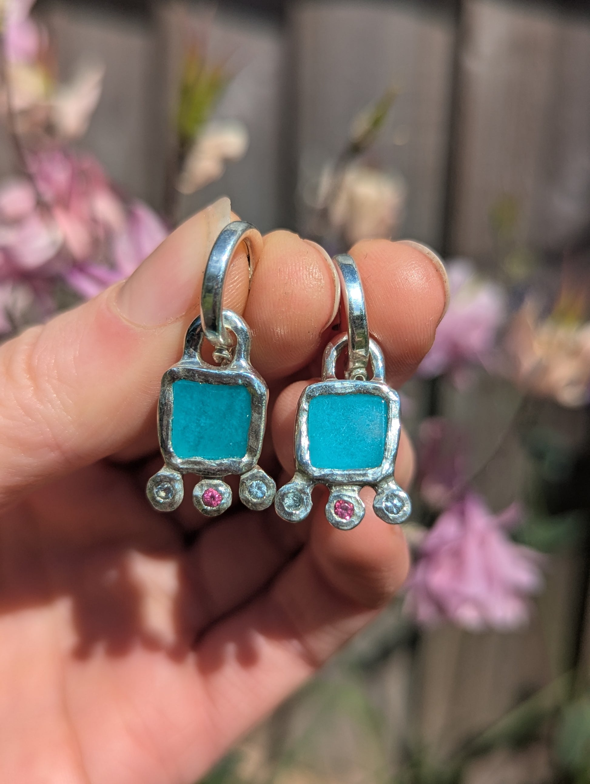 Amazonite, pink topaz and sky blue topaz hoop earring silver charms held in hand
