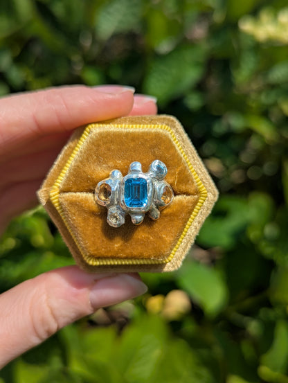 Handmade bohemian silver ring with blue and yellow gemstones in yellow box
