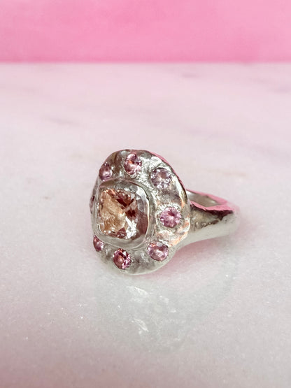 Side view of Cushion cut peach morganite pink tourmaline handmade silver ring on white and pink background
