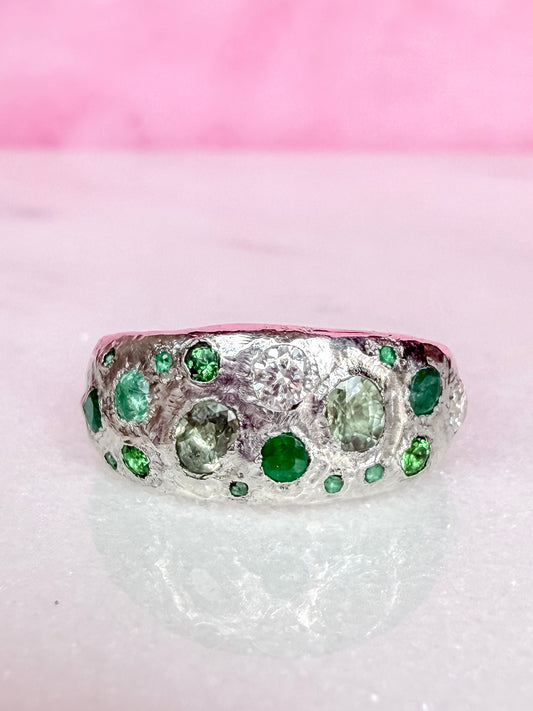 Green sapphire, emerald, tsavorite garnet and moissanite handmade silver ring on white background