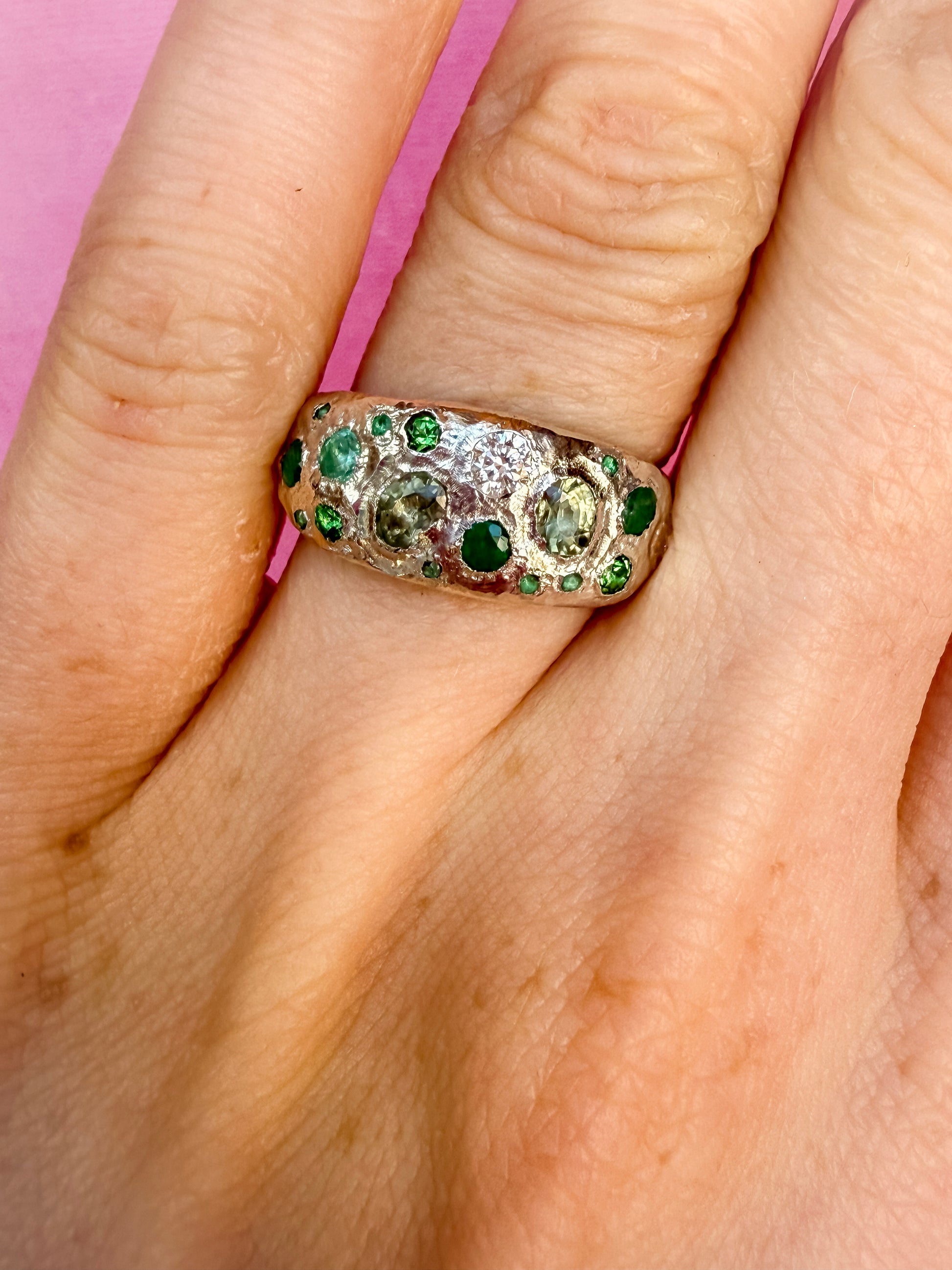 Green sapphire, emerald, tsavorite garnet and moissanite handmade silver ring on hand