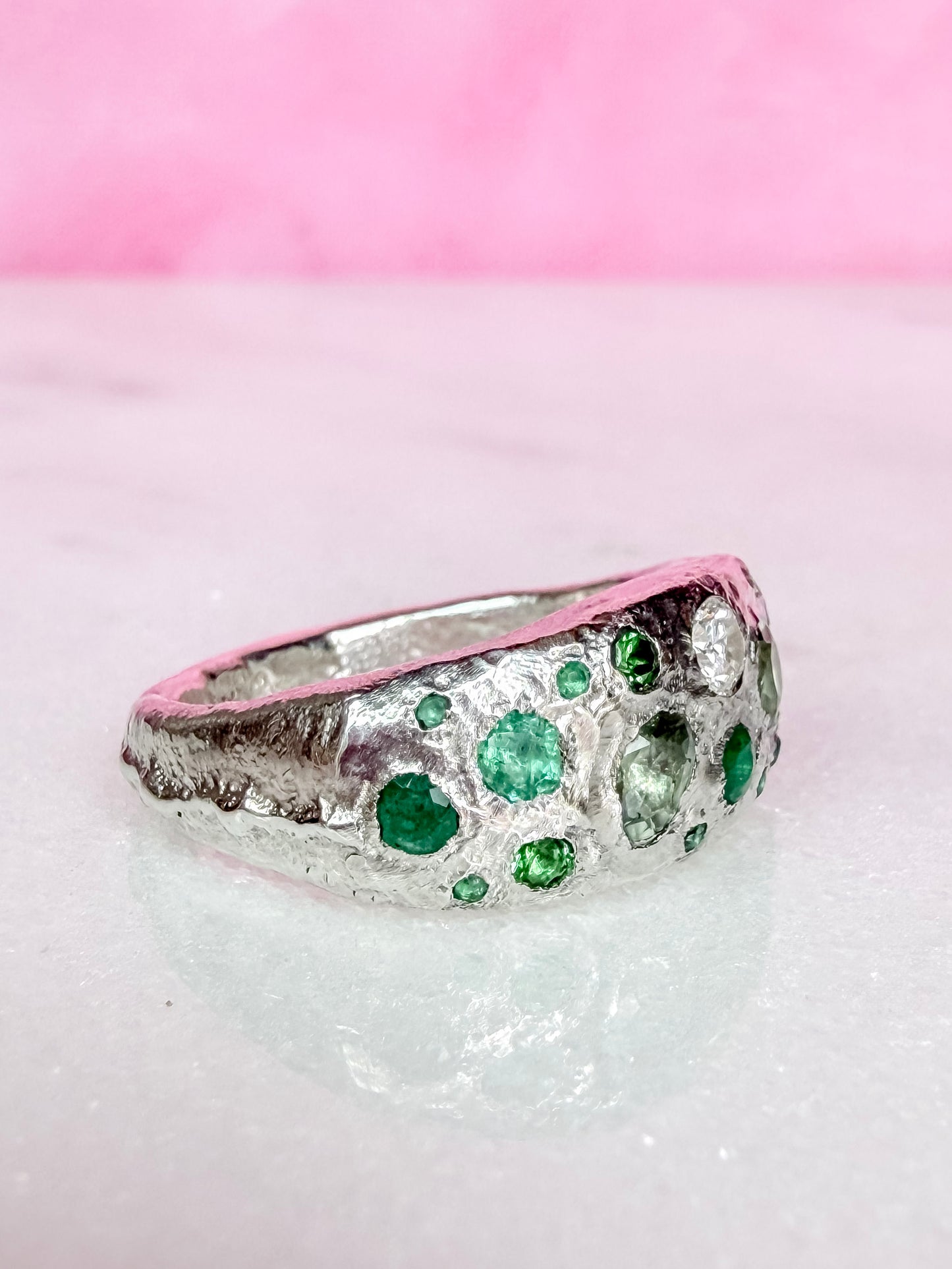 Green sapphire, emerald, tsavorite garnet and moissanite handmade silver ring on white background side view