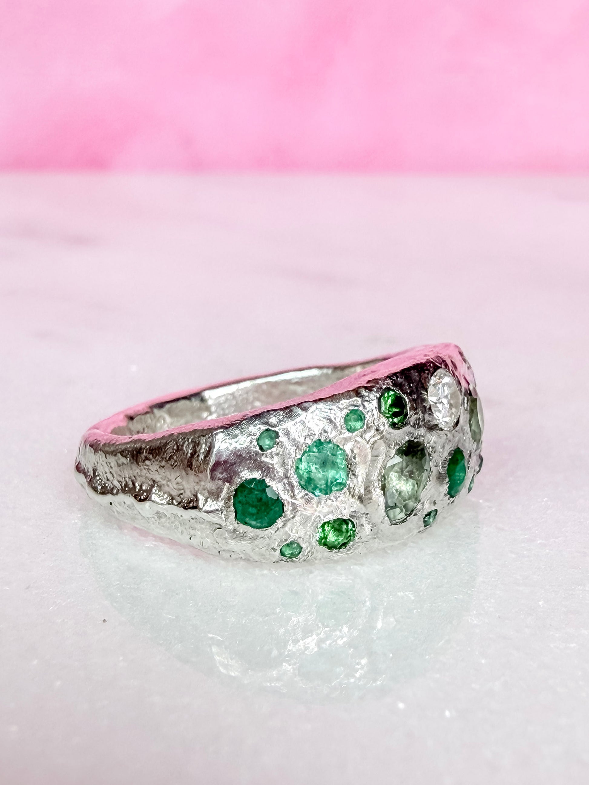 Green sapphire, emerald, tsavorite garnet and moissanite handmade silver ring on white background side view