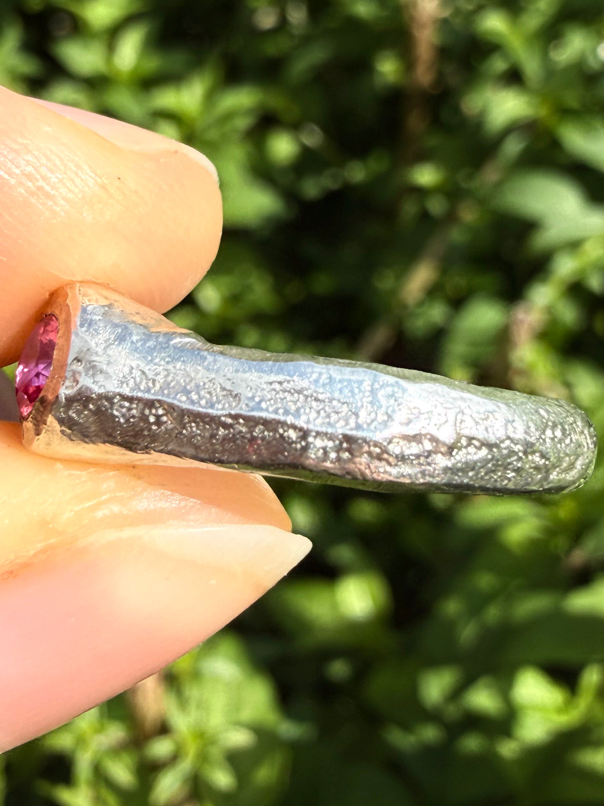 Lab grown octagon ruby and lab grown round pink sapphire handmade silver ring close up of sand cast texture on ring shank