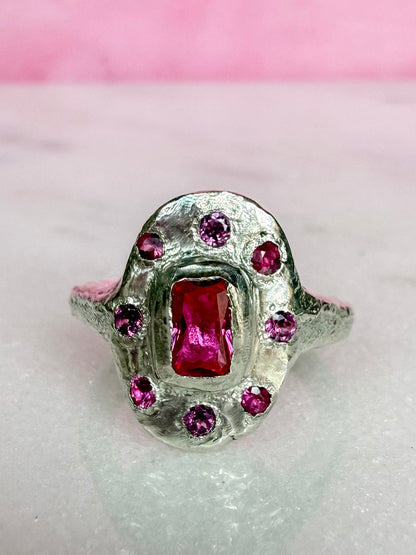 Lab ruby, rhodolite and ruby handmade silver oval ring on marble surface