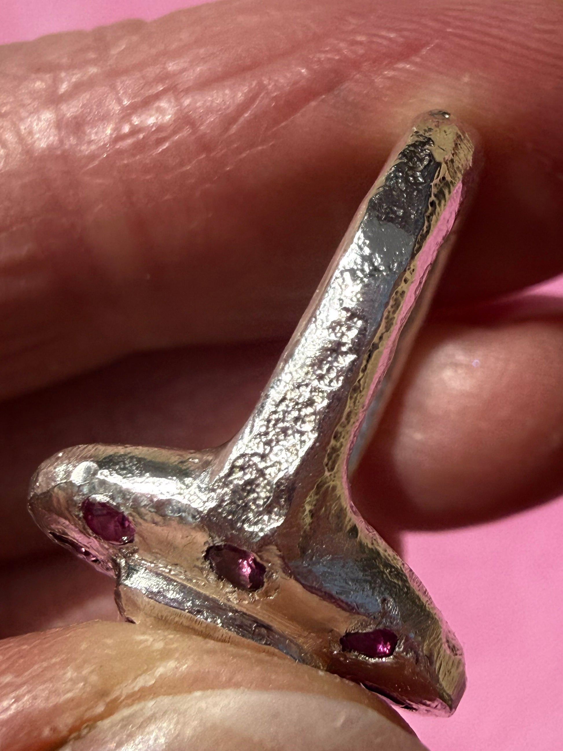 Lab ruby, rhodolite and ruby handmade silver oval ring up close sand cast texture on ring shank