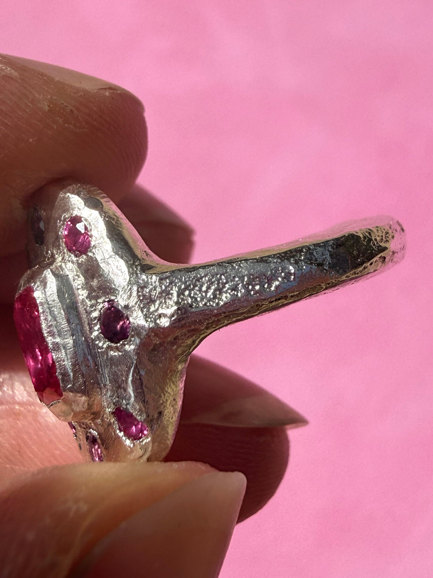 Lab ruby, rhodolite and ruby handmade silver oval ring up close sand cast texture on ring shank 3