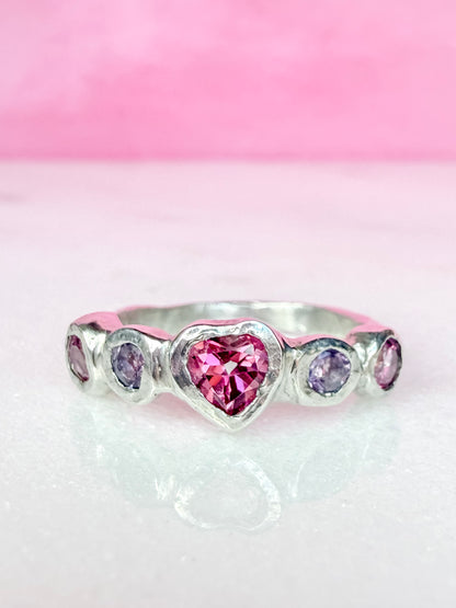 Pink topaz heart, light purple amethyst, and pink topaz handmade silver ring on marble surface