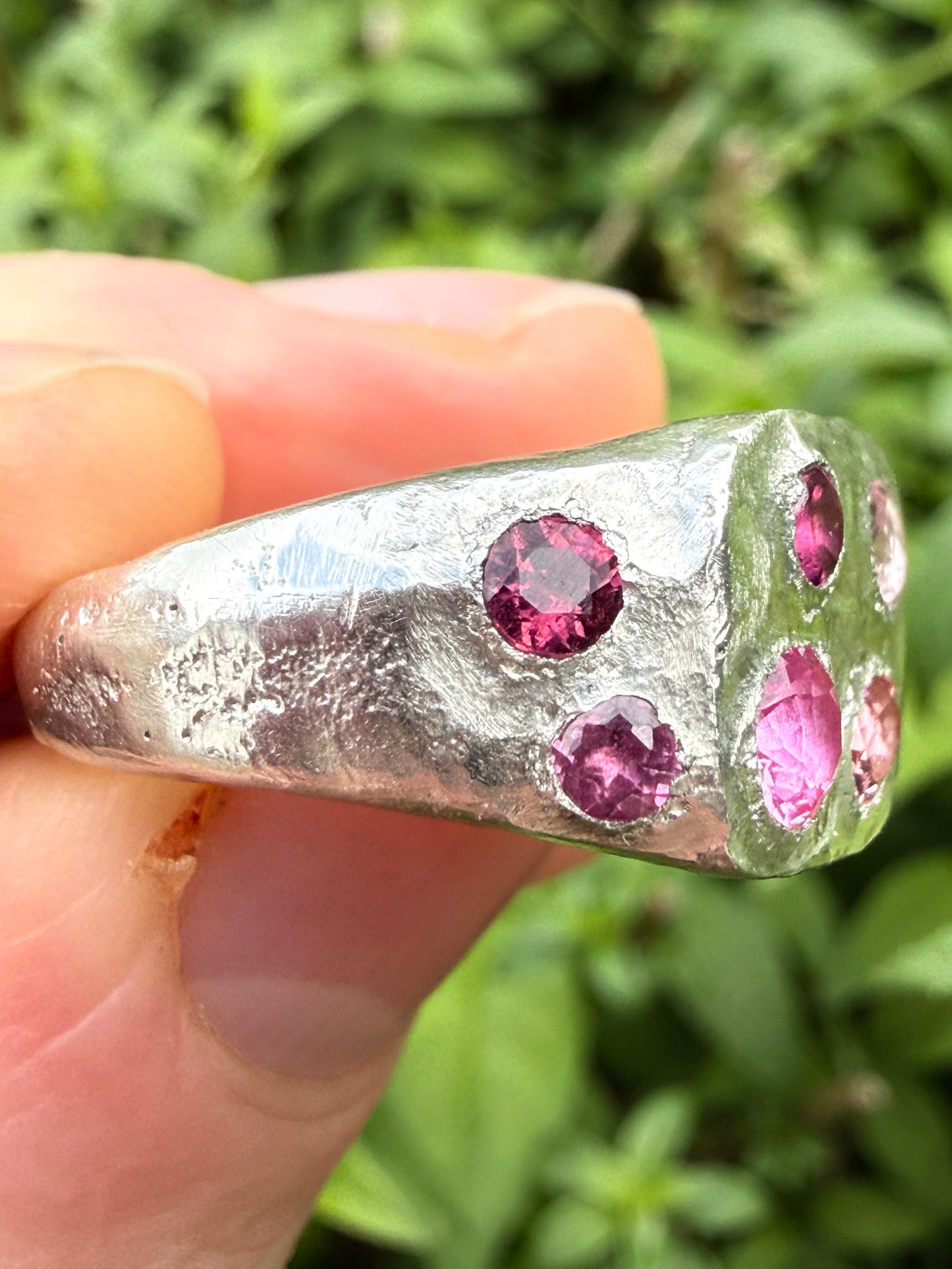 Pink tourmaline and pink sapphire handmade silver signet ring sand cast texture up close side view