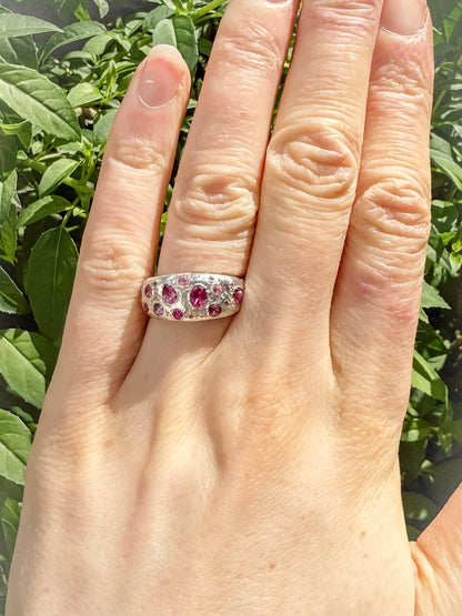 Pink tourmaline, rubelite and ruby handmade silver ring on hand against leafy background