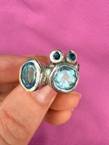 Handmade bohemian ring with blue gemstones on pink background