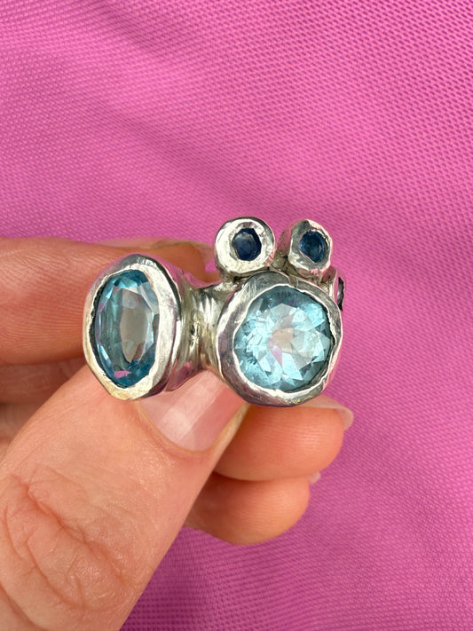 Handmade bohemian ring with blue gemstones on pink background