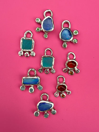 Silver earring charms on pink background
