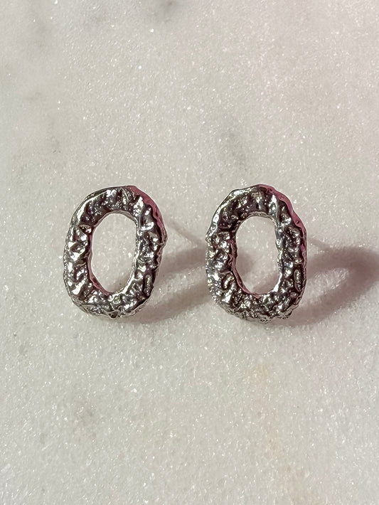 Small Textured Silver Oval Handmade Earrings on marble surface