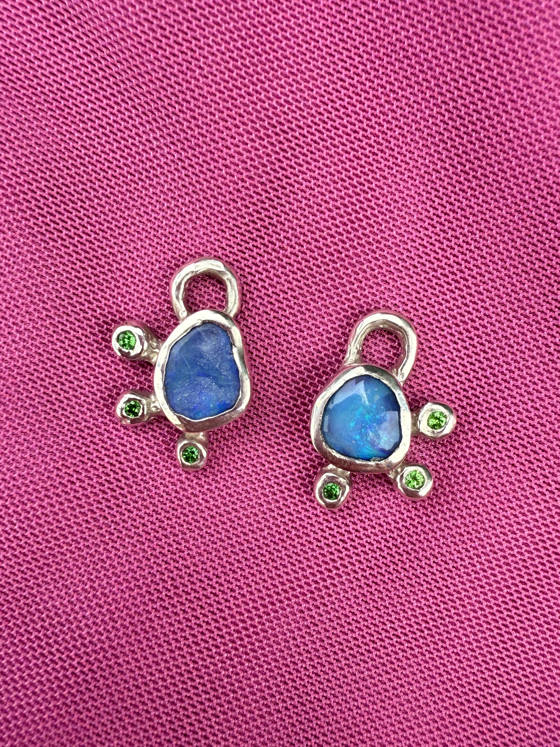 Two silver Australian opal earring charms against pink background