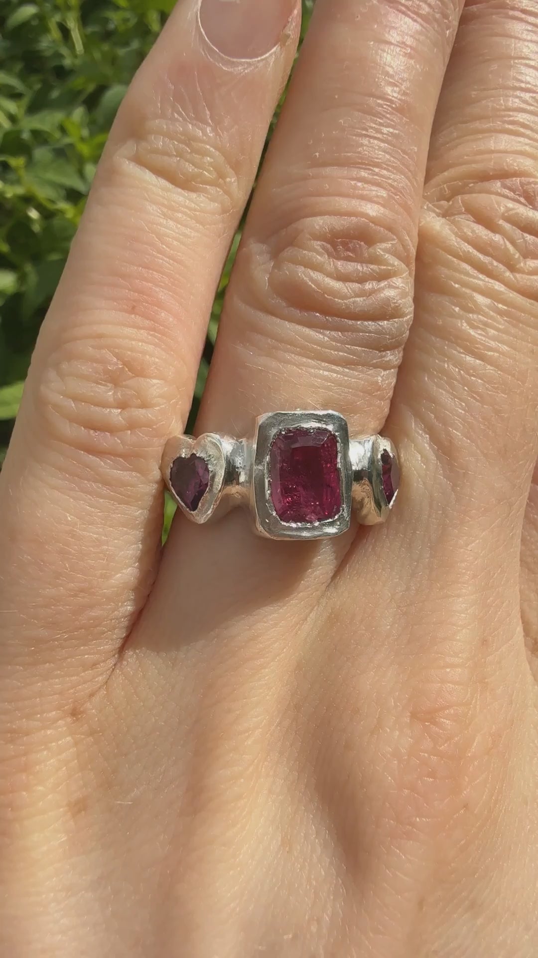 Octagon_cushion_cut_hot_pink_tourmaline_and_purple_rhodolite_heart_handmade_silver_ring_sparkling_in_sunlight