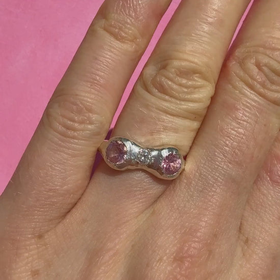 Natural pink tourmaline and lab-grown moissanite handmade silver ring on hand sparkling in the sun
