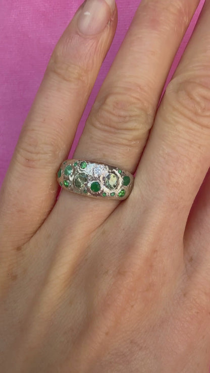 Green sapphire, emerald, tsavorite garnet and moissanite handmade silver ring on hand sparkling in sunlight